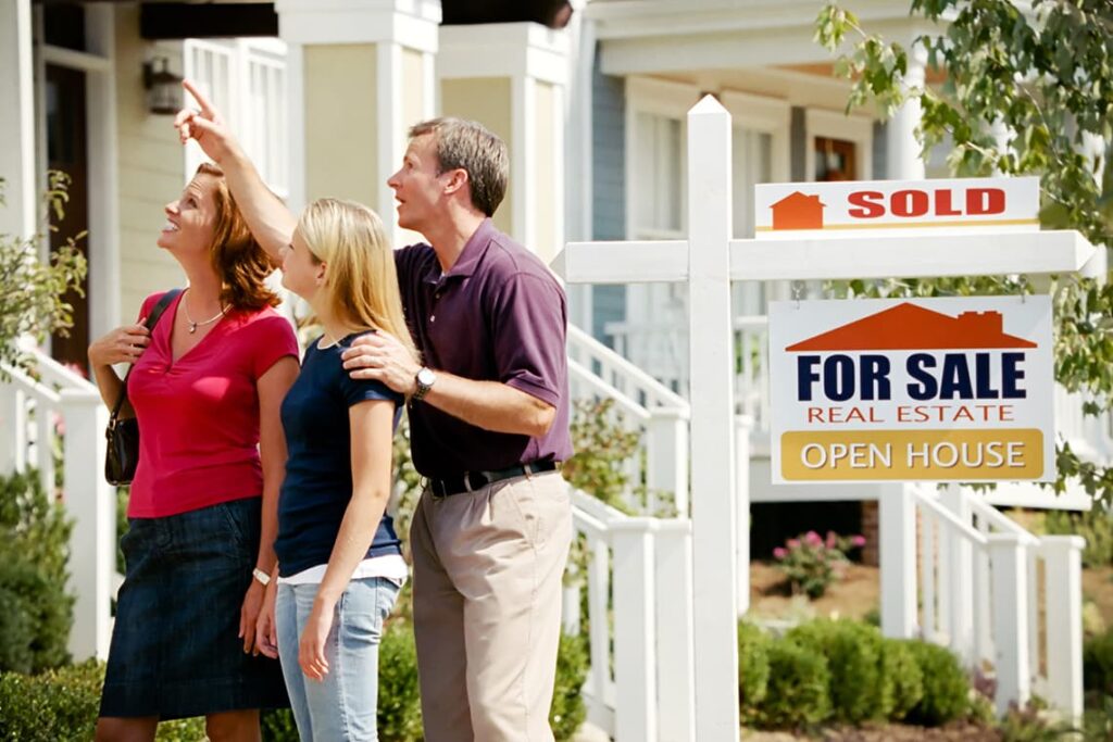 A young family looks up at their new home.